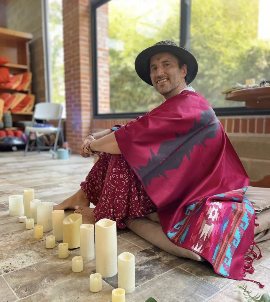 David of Maegical Healing sitting in front of a row of candles. 